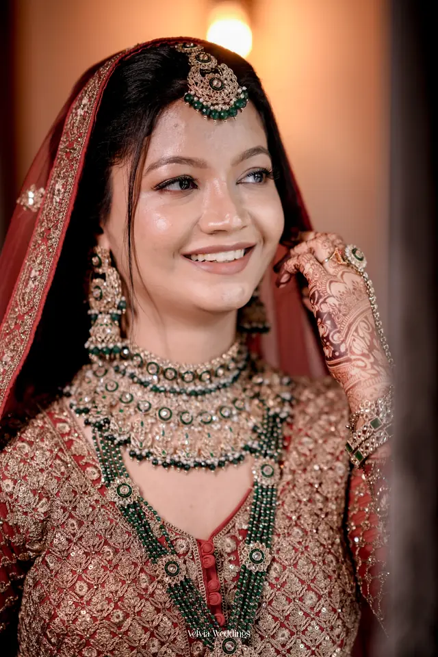 Bride in a red embroidered dupatta with kundan jewellery, makeup by Popy at Popyz Beauty Lounge, Kozhikode
