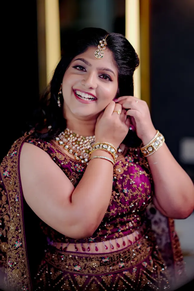 Reception bride in a plum embroidered lehenga with statement jewellery, makeup by Popyz