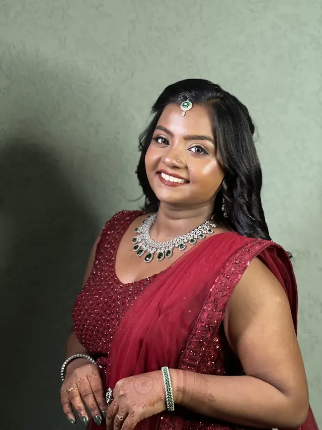 Engagement look: red sequinned lehenga with an emerald and diamond necklace — makeup by Popyz Beauty Lounge, Kozhikode