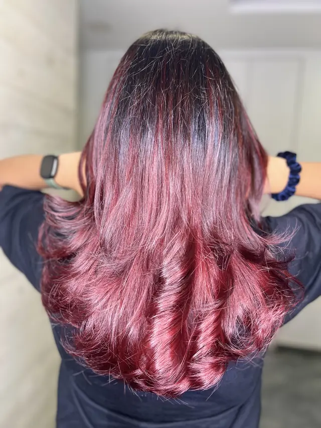 Back view of long wavy hair coloured in rose and burgundy tones