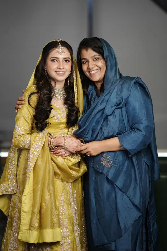 Bride in a gold dupatta sharing a moment with a family member before the Nikah